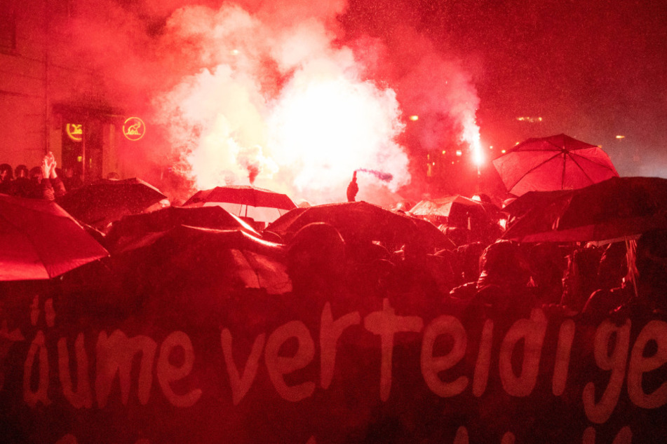 Demonstranten zünden bei einer Demonstration nach der Räumung des besetzten Hauses "Liebig 34" Bengalische Feuer.