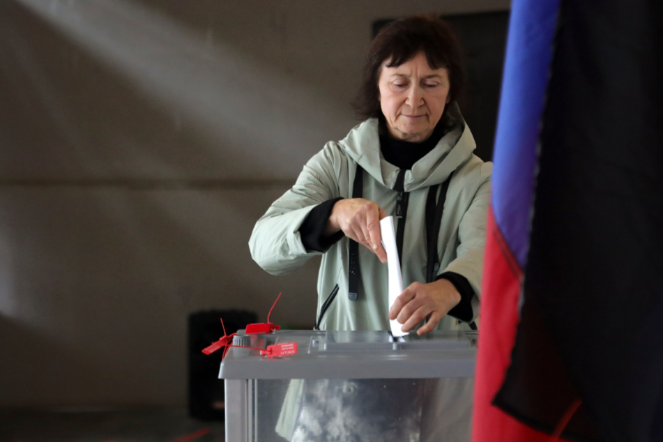 Eine Frau stimmt während des Scheinreferendums in einem Wahllokal in der von den von Russland unterstützten Separatisten kontrollierten Volksrepublik Donezk ab.