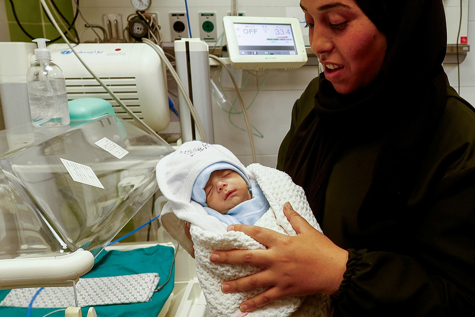 A Palestinian mother holds her newborn Anas Sbeta, who was placed in an incubator after being evacuated from Al Shifa Hospital in Gaza City due to the ongoing Israeli assault.