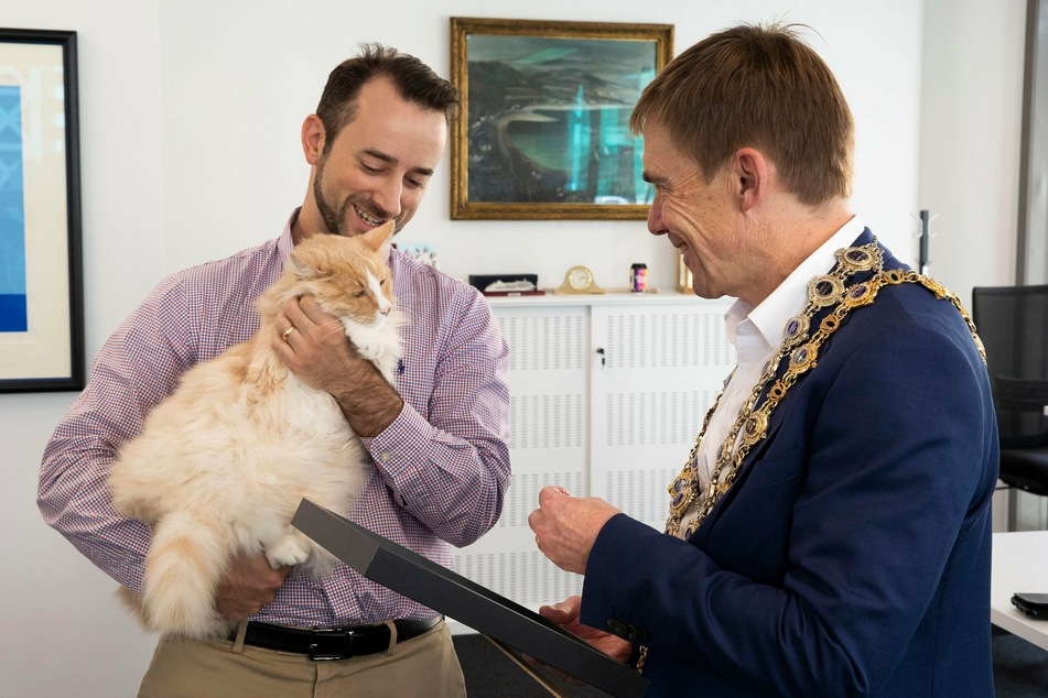 Owner Silvio Bruinsma holds the famous feline in his arms while Mittens is awarded the Key to the City of Wellington.