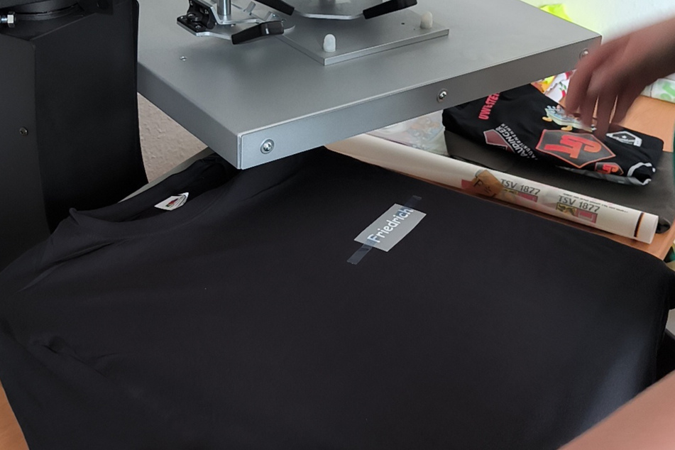 Die Motive werden mithilfe einer Transferdruckmaschine auf die T-Shirts gepresst.