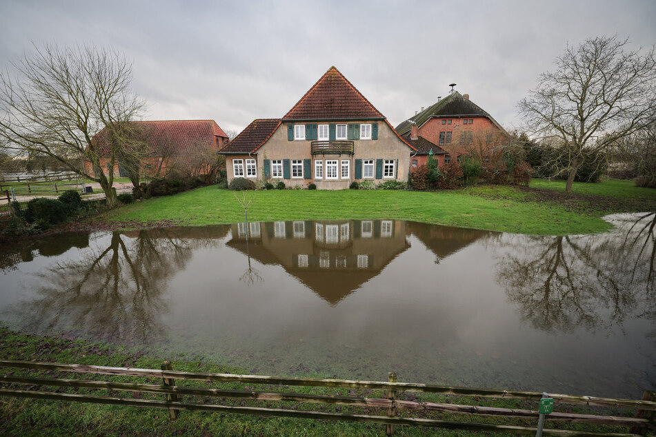Wasser steht auf einer Wiese vor einem Hof in dem kleinen Ort Hagen-Grinden. Die Ortschaft bei Bremen war durch das Hochwasser tagelang von der Außenwelt abgeschnitten.
