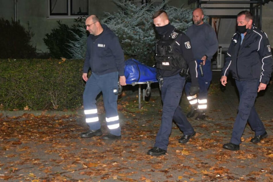 Die Leiche wird abtransportiert.