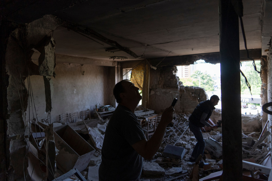 Männer inspizieren ihr Büro, das bei einem nächtlichen Angriff durch eine Drohne zerstört wurde.