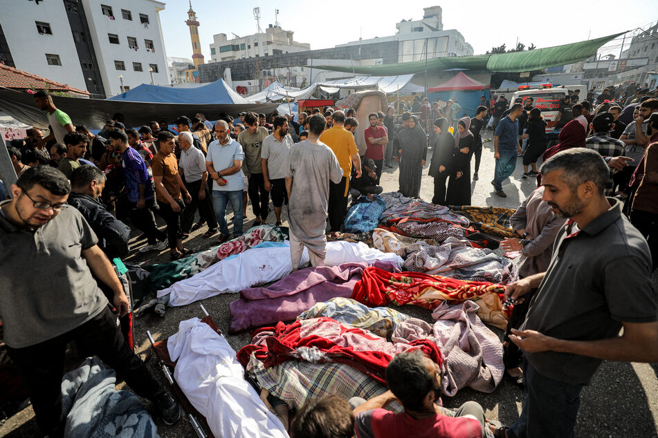 Scores of bodies lying outside of Gaza's Al-Shifa hospital for days have been buried in a mass grave, according to officials.