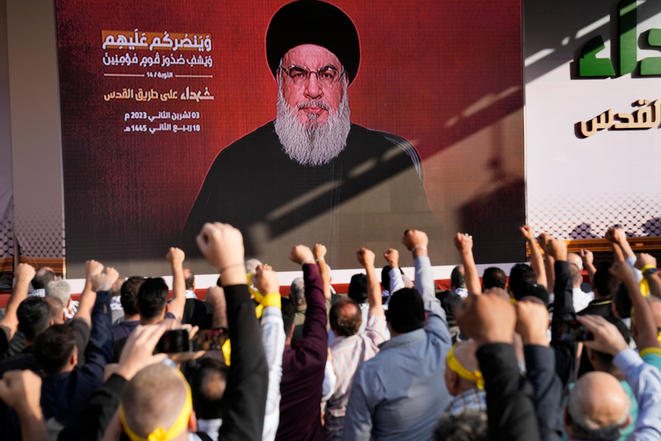 Anhänger der vom Iran unterstützten Hisbollah erheben ihre Fäuste und jubeln, als Hisbollah-Führer Hassan Nasrallah bei einer Videoübertragung erscheint.