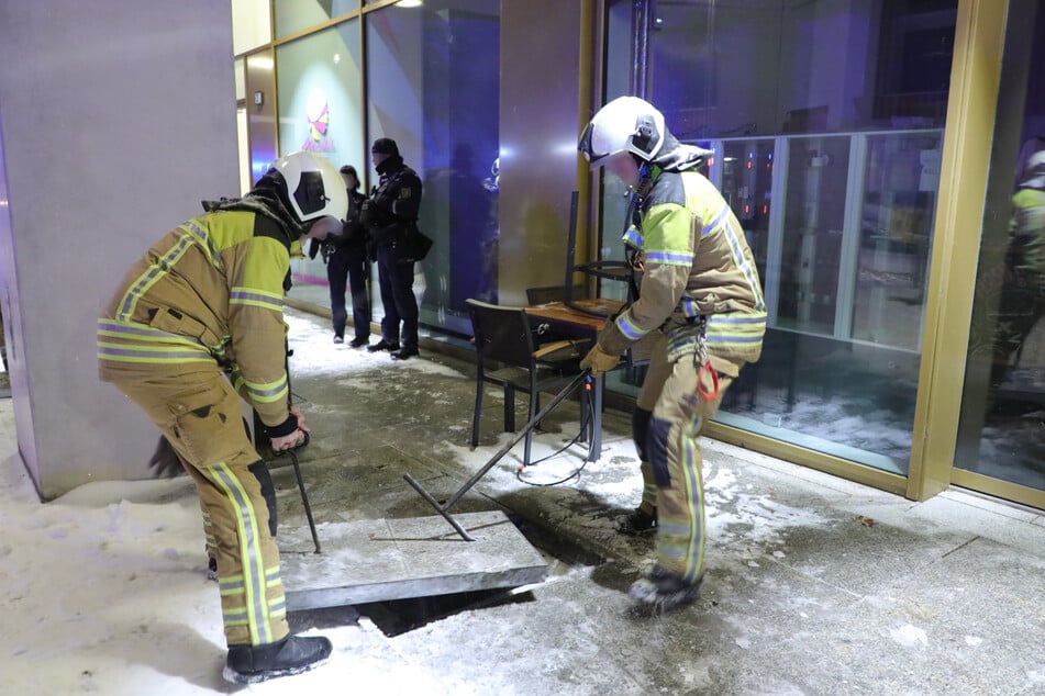 Die Feuerwehr hat zur Belüftung der Kellerräume Gehwegplatten angehoben.