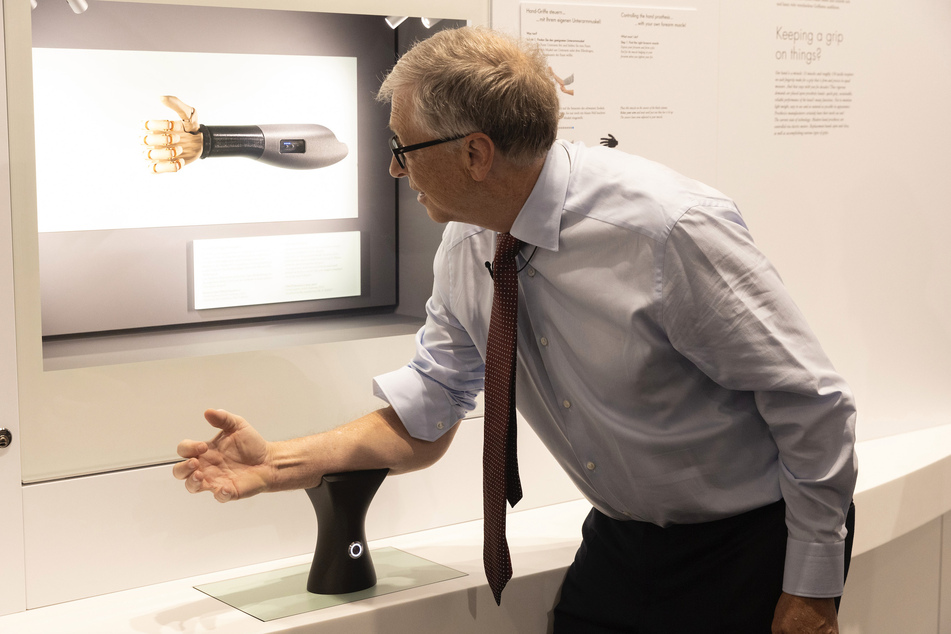 Bill Gates (67) probiert im Deutschen Museum eine Handprothese aus, die sich über die Armmuskeln steuern lässt.