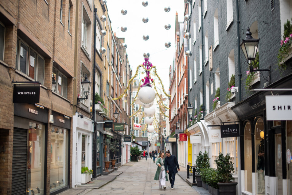 London: Passanten gehen durch die festlich dekorierte Fußgängerzone St Christopher's Place vorbei an geschlossenen Geschäften.