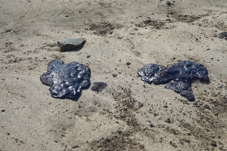Oil clumps from the growing oil spill have been washing ashore on Huntington Beach.