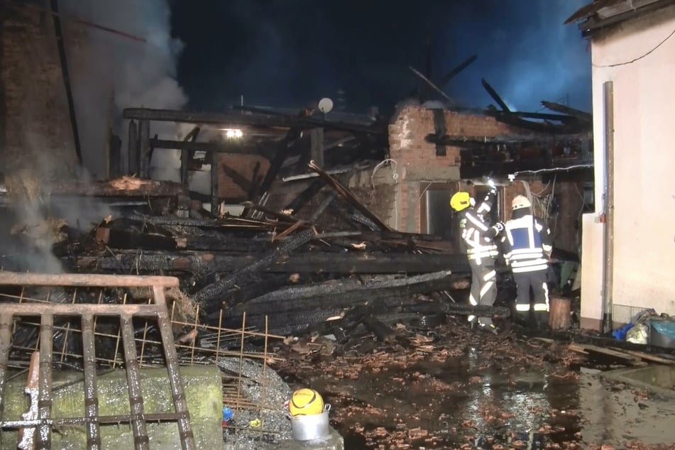 Feuerwehrleute löschen den Brand. Zunächst stand eine Scheune in Flammen, die anschließend auf ein Wohnhaus übergriffen.