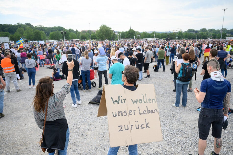 Ein Mann steht während einer Protestkundgebung der Initiative "Querdenken 711" mit einem Schild, auf dem "Wir wollen unser Leben zurück" steht, auf dem Cannstatter Wasen.
