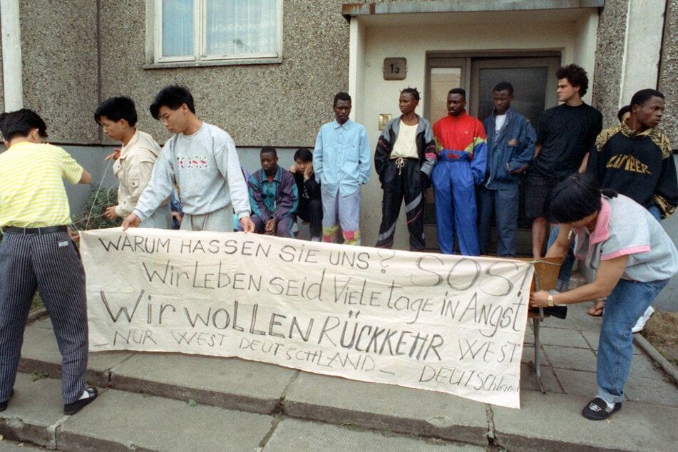 "Warum hassen Sie uns" steht auf einem Plakat, das Asylbewerber hochhalten. (Archivbild).
