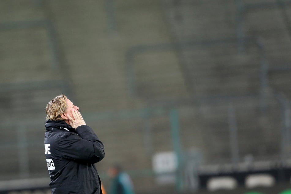 Der Kölner Trainer Markus Gisdol schaut zum Himmel. Das Spiel findet wegen des Coronavirus ohne Zuschauer als Geisterspiel statt.
