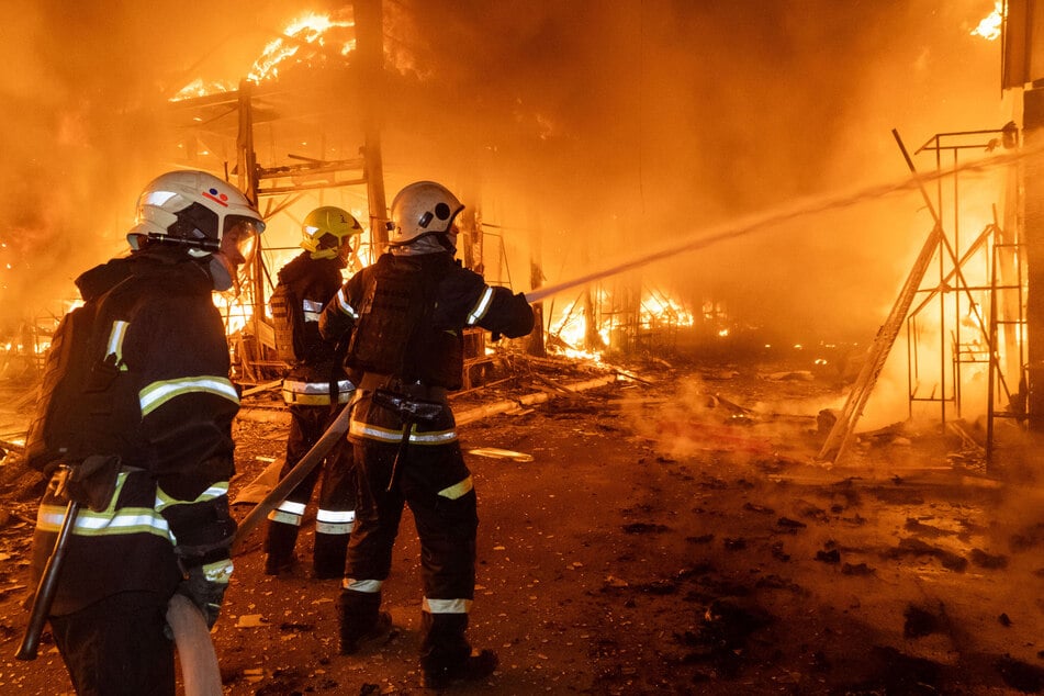 Feuerwehrleute bekämpfen den Brand nach einem russischen Luftangriff auf den Barabaschowo-Markt in Charkiw.