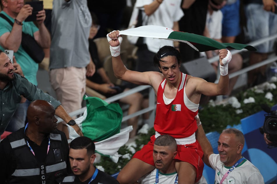 Imane Khelif raises the Algerian flag as she celebrates her gold medal win in the women's 66kg boxing competition at the Paris Olympics.