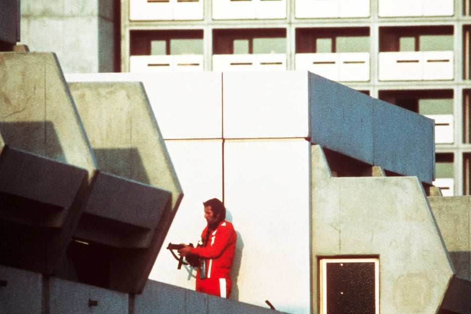 Ein bewaffneter Polizeibeamter im Trainingsanzug sichert am 5. September 1972 im Olympischen Dorf in München den Block, in dem Terroristen die israelischen Geiseln festhalten.