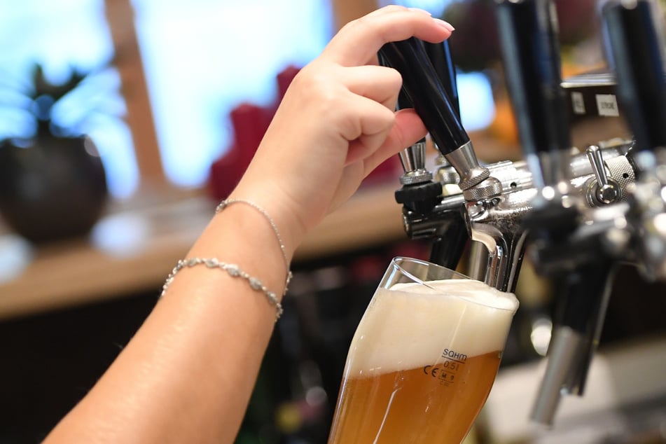 Eine Bedienung zapft Bier in einem Wirtshaus.