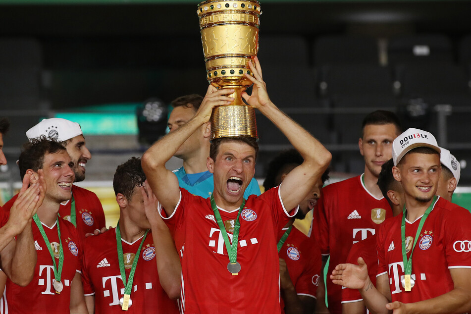 Thomas Müller vom FC Bayern München balanciert den DFB-Pokal auf seinem Kopf. Die Münchner haben die Trophäe für die Saison 2019/2020 gewonnen.