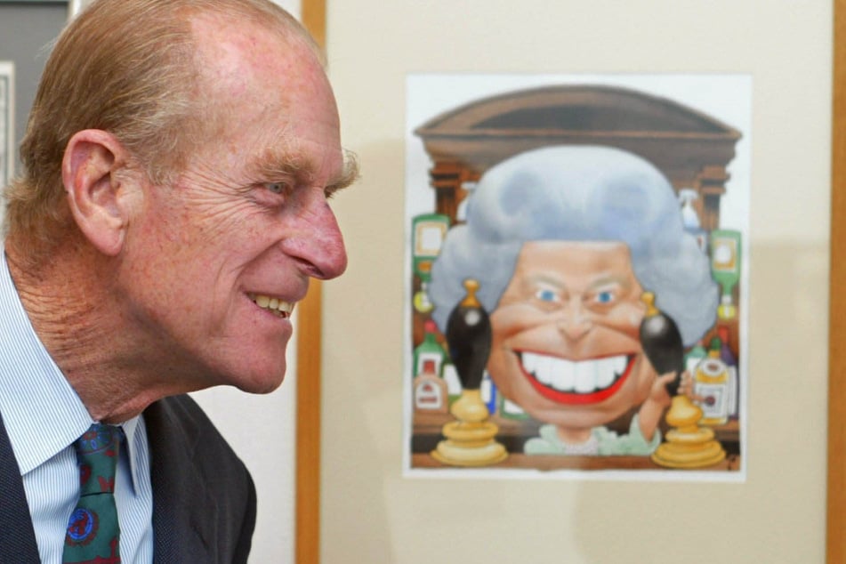 12. April 2002: Prinz Philip lächelt beim Betrachten einer Trogg-Karrikatur zum Thronjubiläum der Queen.