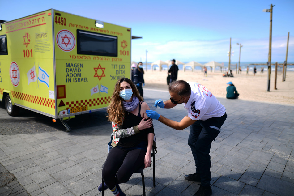 Geimpft wird in Israel an vielen Orten. Hier erhält eine Frau mitten auf den Straßen in Tel Aviv den Corona-Impfstoff von Biontech/Pfizer.