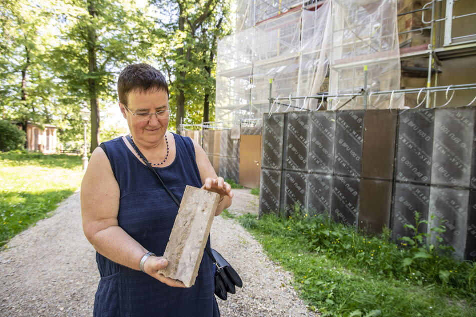 Pfarramtsleiterin Gabriele Führer (59) zeigt einen der Chemnitzer Porphyrtuff-Steine.