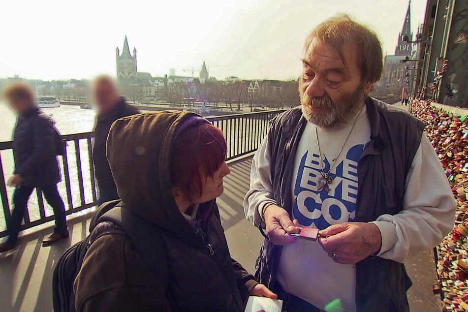 Mit Lothar bringt Carola ein Liebesschloss auf der Kölner Hohenzollernbrücke an.