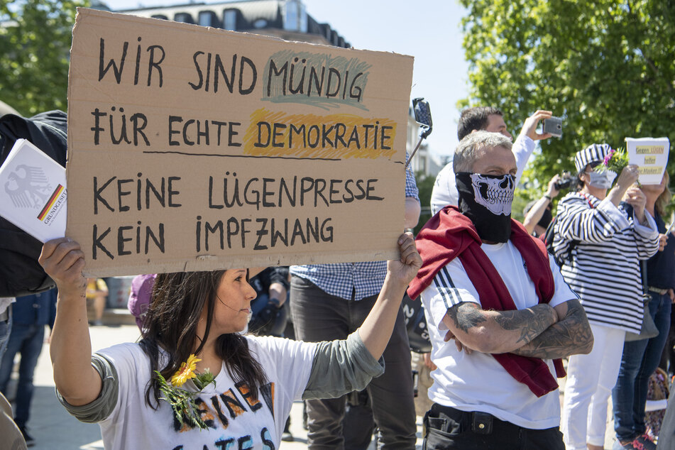 Gegen die "Lügenpresse" und einen "Impfzwang" richtet sich die Aufschrift auf dem Plakat einer Frau, die sich vor der Alten Oper in Frankfurt an einer Kundgebung gegen die Corona-Maßnahmen der Regierung richtete.