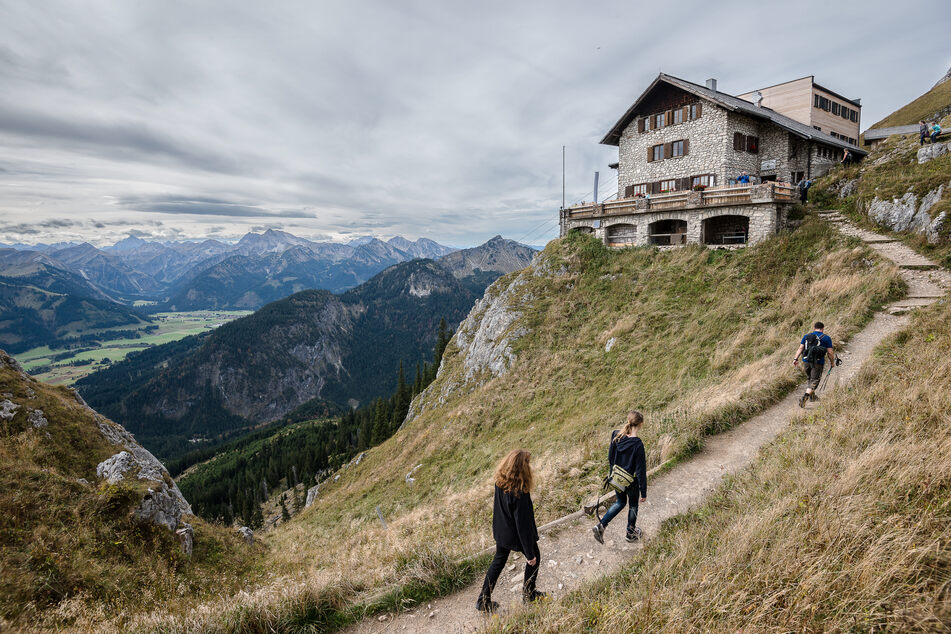 Wanderer gehen zur Bad Kissinger Hütte des Deutschen Alpenvereins (DAV).