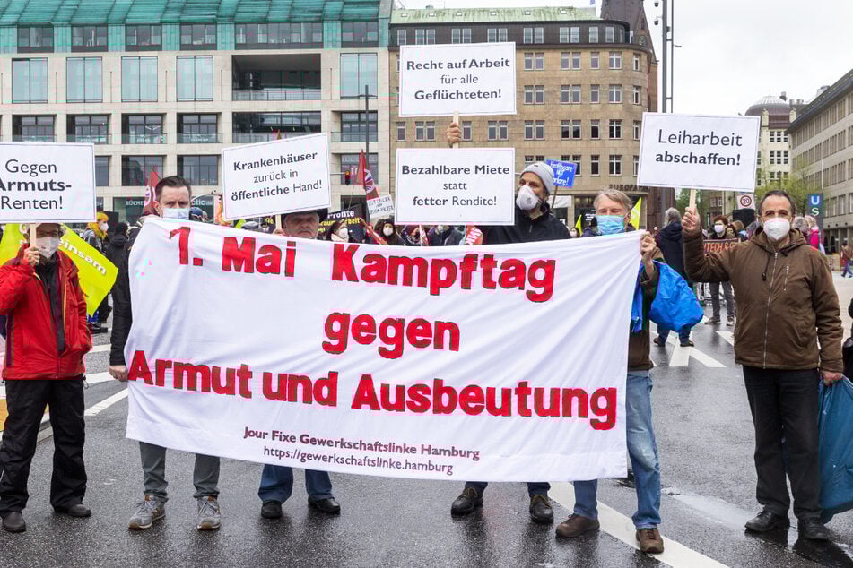 Teilnehmer halten ein Transparent mit der Aufschrift "1. Mai Kampftag gegen Armut und Ausbeutung" hoch. Linke Gruppen haben heute unter dem Motto "Sozialer Protest lässt sich nicht verbieten" in Hamburg demonstriert.