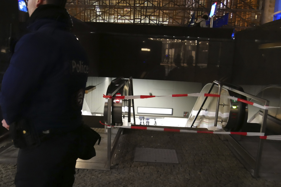 Ein Polizist steht vor einem Absperrband an einer U-Bahn-Station in der Nähe des EU-Sitzes.