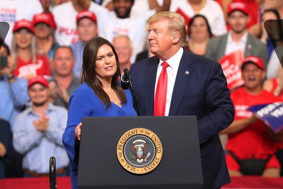 Donald Trump standing on stage with Sarah Huckabee Sanders at a rally in Orlando, Florida on June 18, 2019.