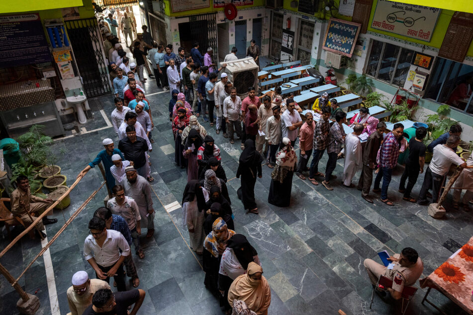 Wähler stehen an einem Wahllokal in Neu-Delhi an.