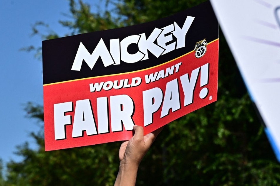 A Disneyland employee holds up a sign reading "Mickey Would Want Fair Pay!" during a rally in Anaheim, California.