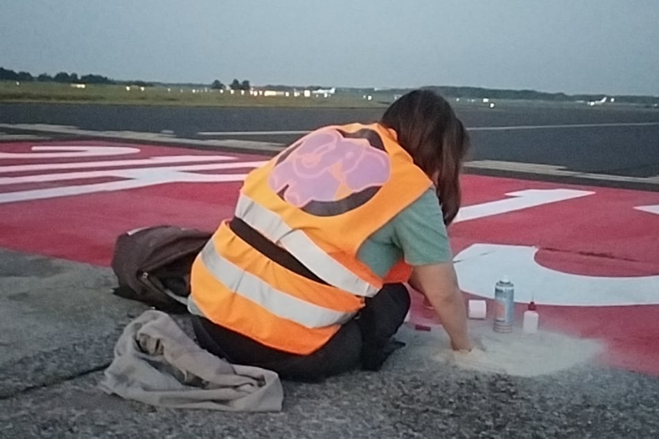 Mit orangenen Warnwesten bekleidet betraten zwei Klimaaktivisten am Mittwochmorgen die Rollbahn am Flughafen Köln/Bonn.