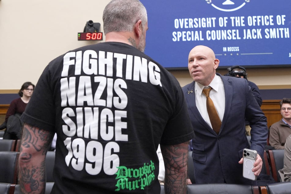 Ivan Raiklin (R) speaks with former Metropolitan Police Department officer Michael Fanone (L) during a hearing on Capitol Hill on Thursday in Washington, DC.