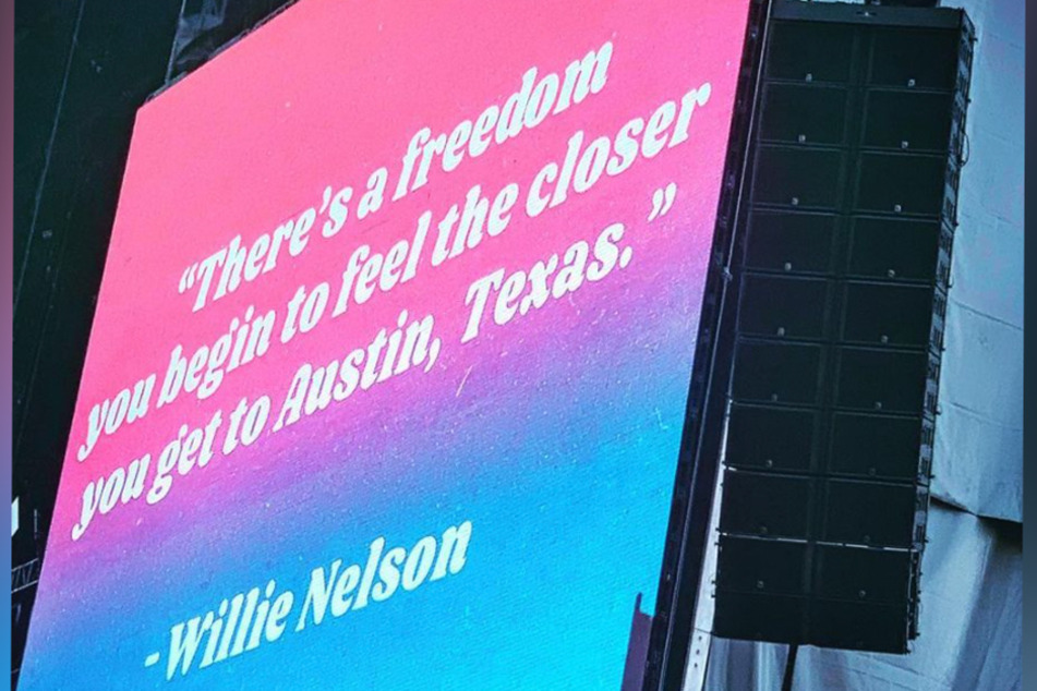 A screen displays a quote by Willie Nelson next to one of the main stages at Austin City Limits Music Festival in October 2019.