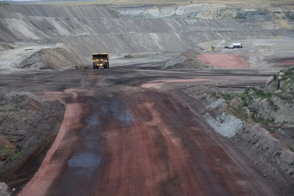 A coal loader vehicle drives through an open pit mine in the Powder River Basin of Wyoming.