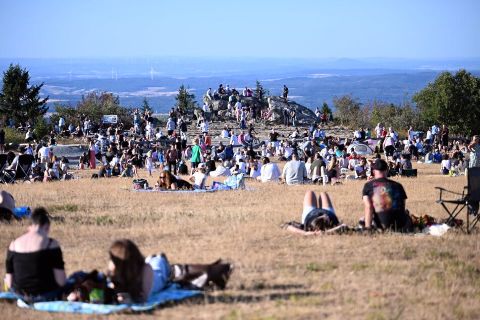 Menschen schauen sich die Sonnenfinsternis auf dem Feldberg im Taunus an.