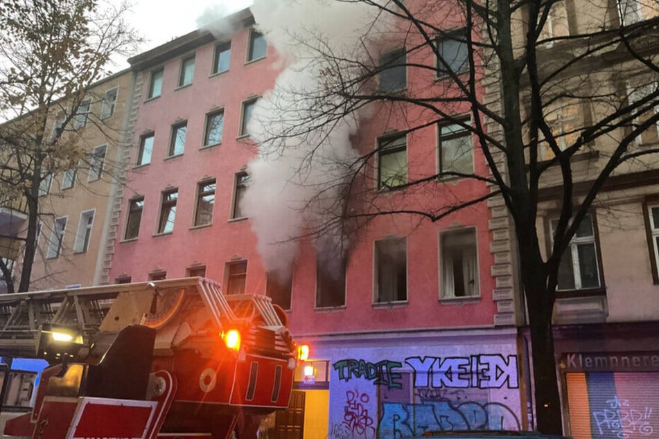 Dichte Rauschschwaden dringen aus einer Wohnung im ersten Obergeschoss und hüllen die Fassade ein.