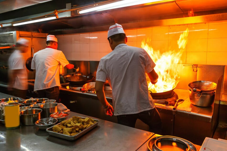 Mitarbeiter eines Restaurants stehen in einer Küche. (Symbolbild)