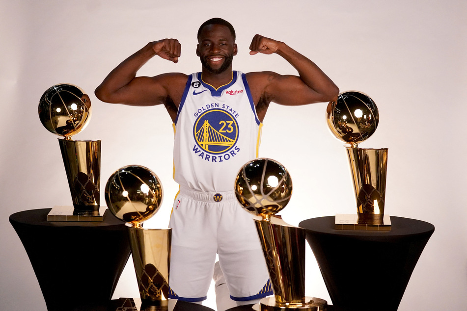 Warriors forward Draymond Green poses with his four NBA titles.