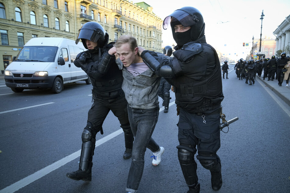 Ein Protestant wird in St. Petersburg von russischen Sicherheitskräften in Gewahrsam genommen.