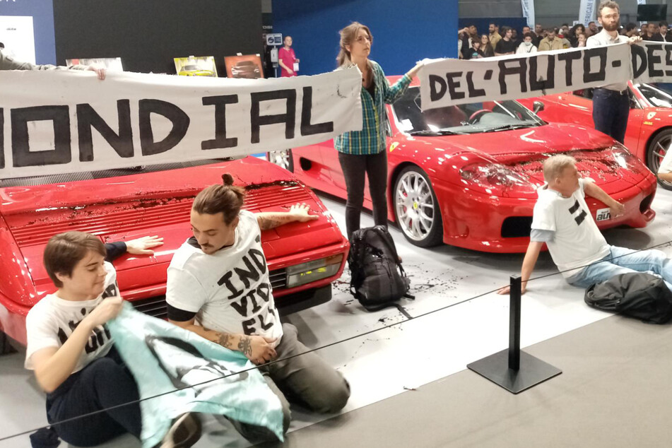 Anders als noch vor wenigen Tagen in Wolfsburg verzichteten diese Klima-Aktivisten, sich am Boden festzukleben. Stattdessen klebten sie ihre Hände direkt auf die Motorhaube dieses Ferrari Mondial.