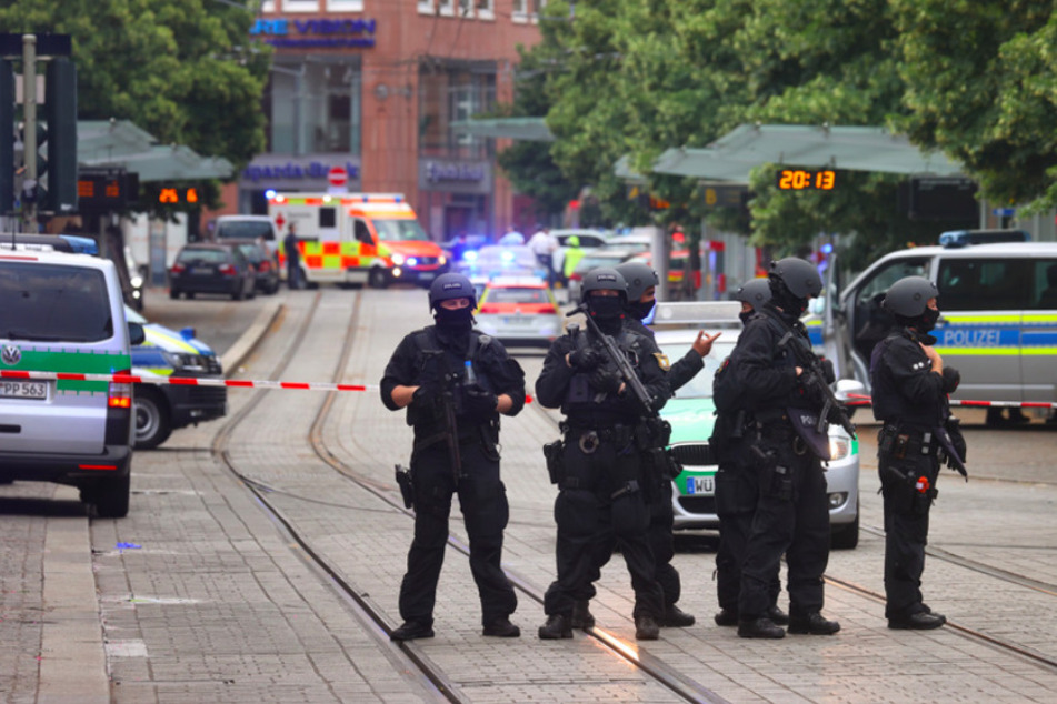 Polizisten stehen in Würzburg. Bei dem Angriff in der Innstadt wurden drei Frauen getötet und sieben Menschen verletzt.