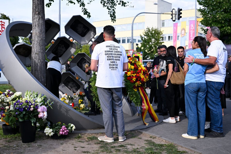 Angehörige der Opfer stehen beim Gedenkakt anlässlich des 10. Jahrestags des Attentats am Olympia-Einkaufszentrum am Denkmal „Für Euch“.