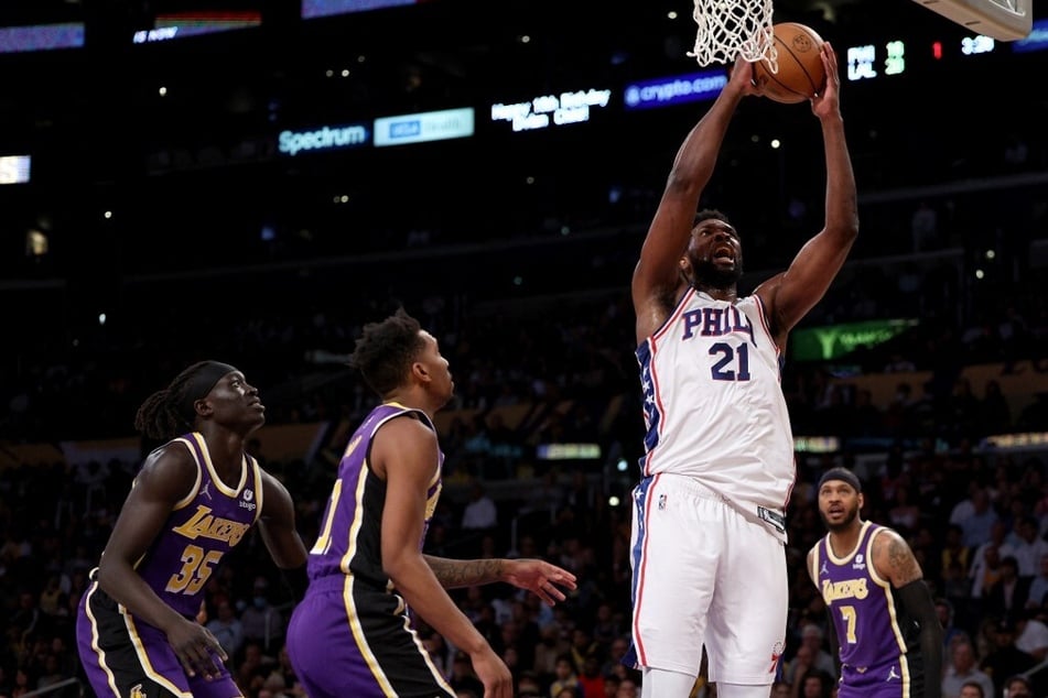 Joel Embiid of the Philadelphia 76ers attempts a shot in front of Wenyen Gabriel, Malik Monk, and Carmelo Anthony of the Los Angeles Lakers.
