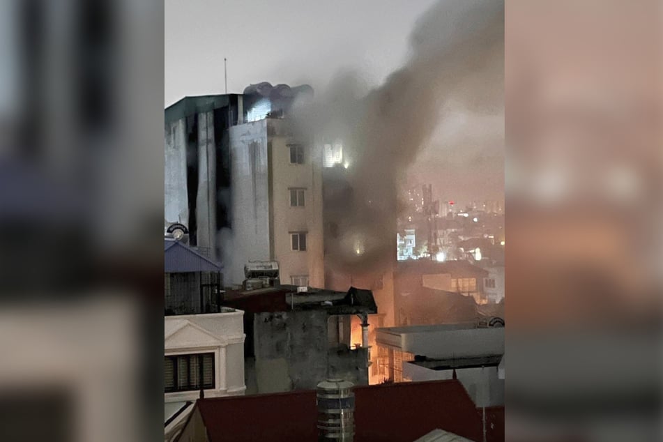 Eine riesige Rauchsäule steigt aus dem brennenden Gebäude in Hanoi.