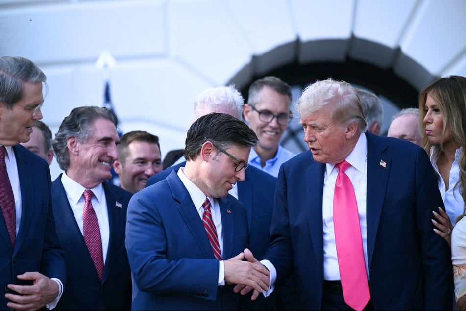 President Donald Trump shakes hands with House Speaker Mike Johnson after signing the "Big Beautiful Bill Act" at the White House in Washington DC on July 4, 2025.