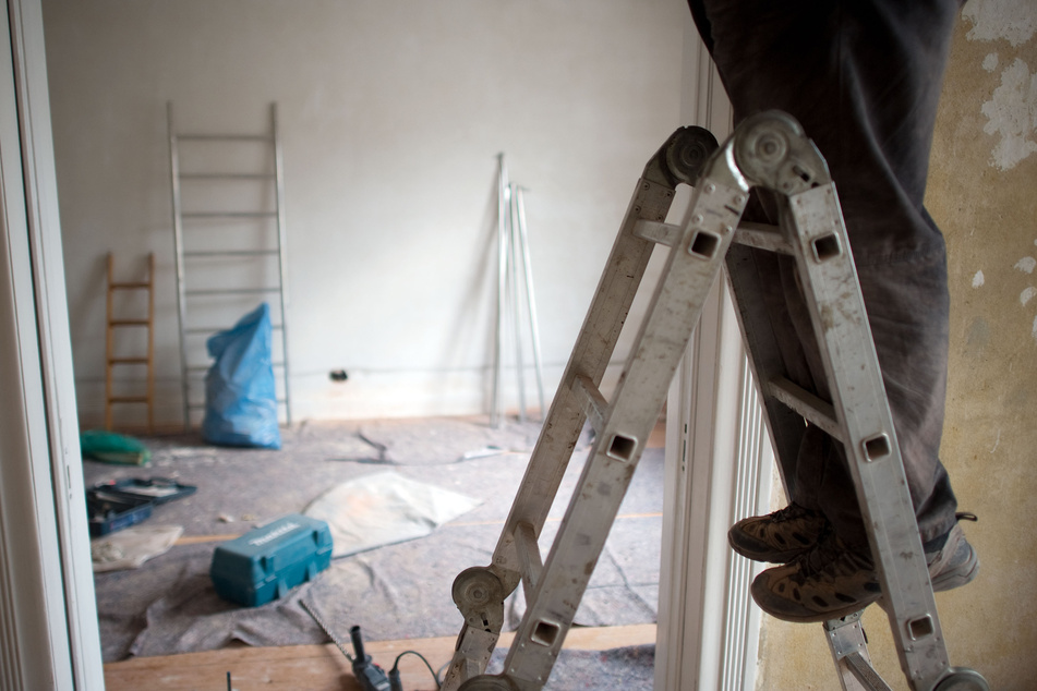 Ein Handwerker arbeitet in einer Wohnung.